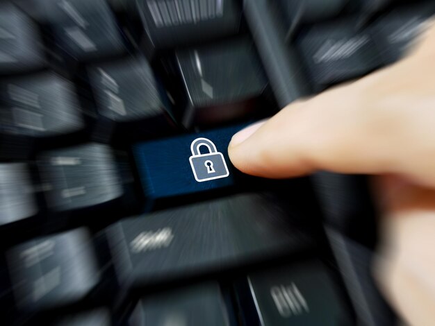 Photo cropped image of person pressing lock button on keyboard