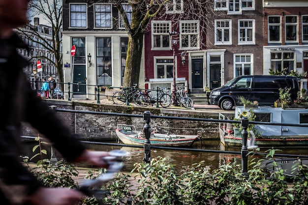Photo cropped image of person riding bicycle by canal