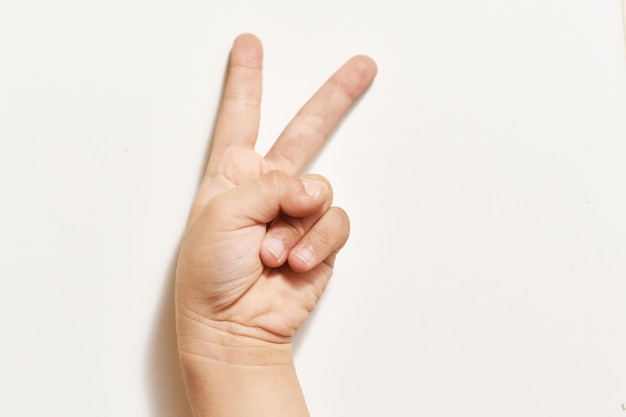 cropped image of person showing peace sign against white background