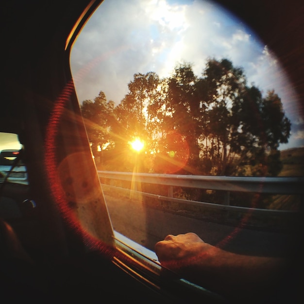 Foto immagine ritagliata di una persona che viaggia contro il sole brillante durante il tramonto