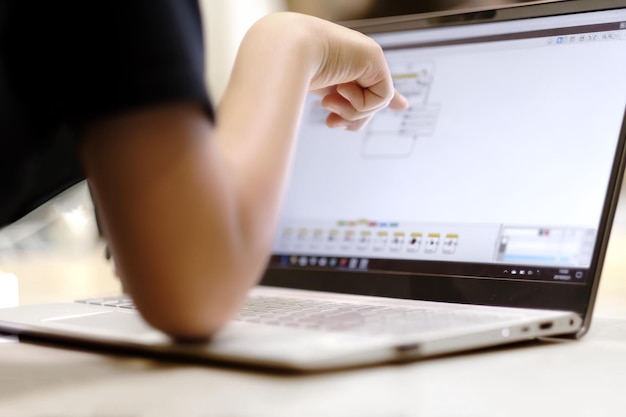 Photo cropped image of person using laptop on table