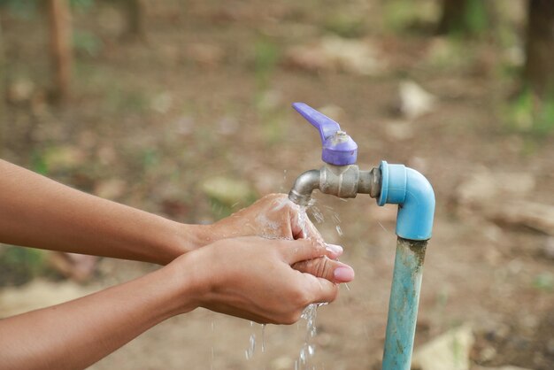 Cropped image of person washing hands at faucet