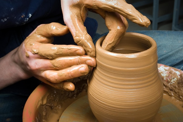 cropped image of potter making clay pot