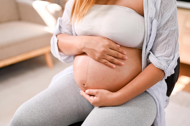 Cropped image of a pregnant woman touching her belly feeling her baby in her tummy with love