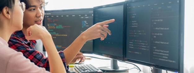 Cropped image of professional programer team collaboration discuss about web coding while coworker point java script displayed on computer at modern company office Closeup Burgeoning