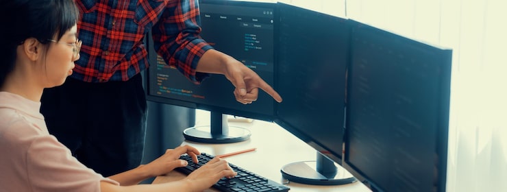 Photo 전문 프로그래머 팀 협업의 절단 이미지 웹 코딩에 대해 토론하는 동안 동료가 현대 회사 사무실에서 컴퓨터에 표시되는 자바 스크립트를 지적합니다 closeup burgeoning