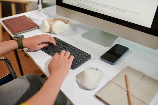 Cropped image of programmer reviewing code on computer screen