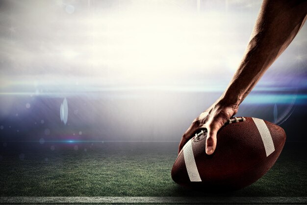 Photo cropped image of sports player holding ball against american football arena