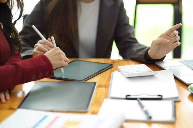 L'immagine ritagliata dell'imprenditrice d'affari di successo discute insieme un nuovo prodotto di lancio e pianifica la strategia di marketing. tavoletta sul tavolo.