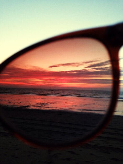 Foto immagine ritagliata del tramonto sul mare vista da occhiali da sole