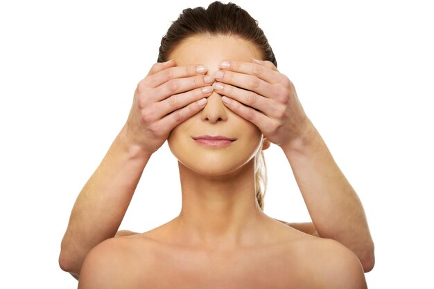 Photo cropped image of woman covering girlfriend eyes against white background