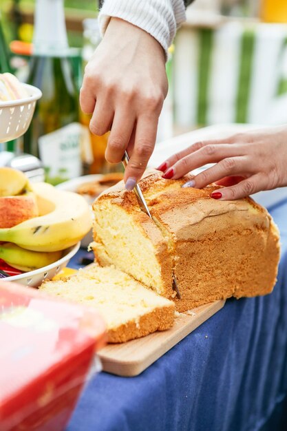Cropped image of woman cutting bread loaf