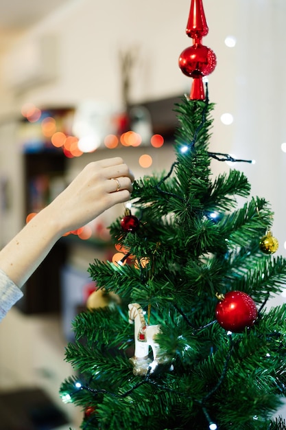 Foto immagine ritagliata di una donna che decora l'albero di natale