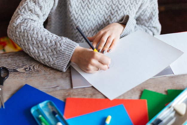 Cropped image of a woman drawing on paper