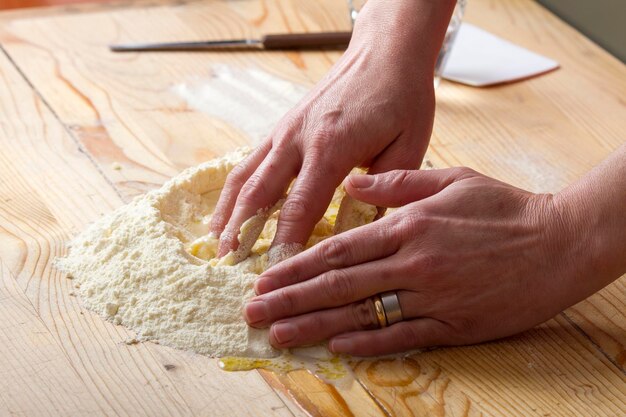 Cropped image of woman hand preparing ravioli dough on table