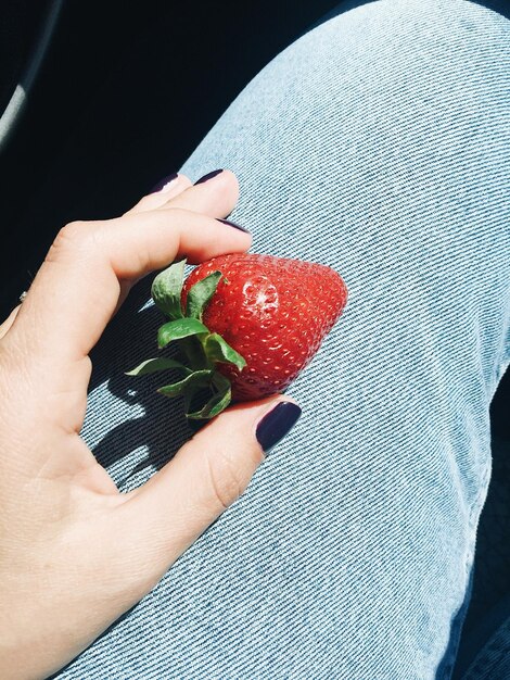 Foto immagine ritagliata di una donna che ha una fragola