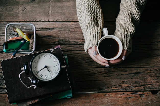 Photo cropped image of woman holding coffee cup on table