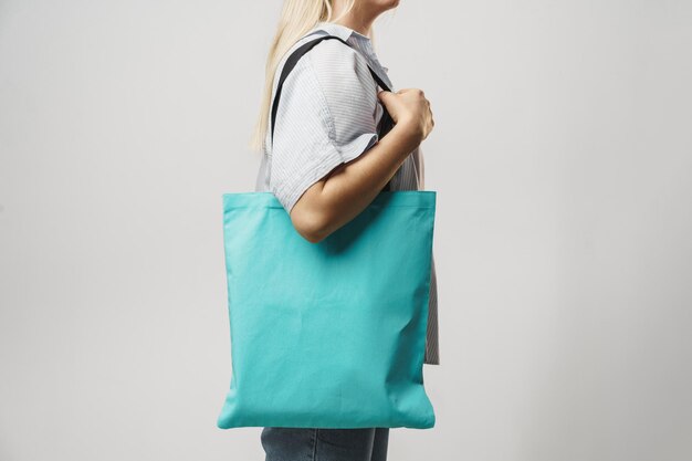 Cropped image of woman holding color shopping bag in studio