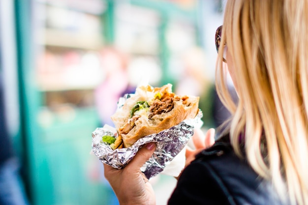 Foto immagine ritagliata di una donna che tiene un hamburger.