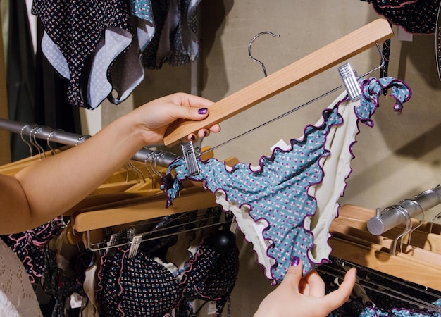 店でランジェリーを握っている女性のカットされた画像