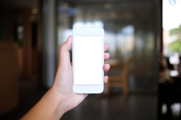 Cropped image of woman holding mobile phone at home