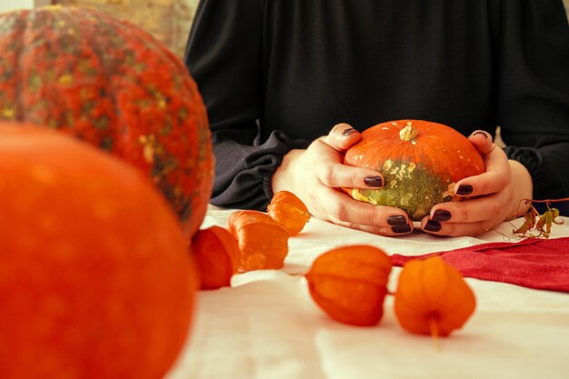 Cropped image of a woman holding a pumpkin in her hands