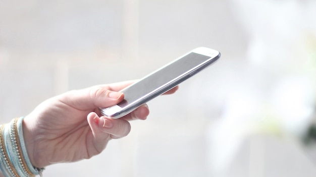 Photo cropped image of woman holding smart phone