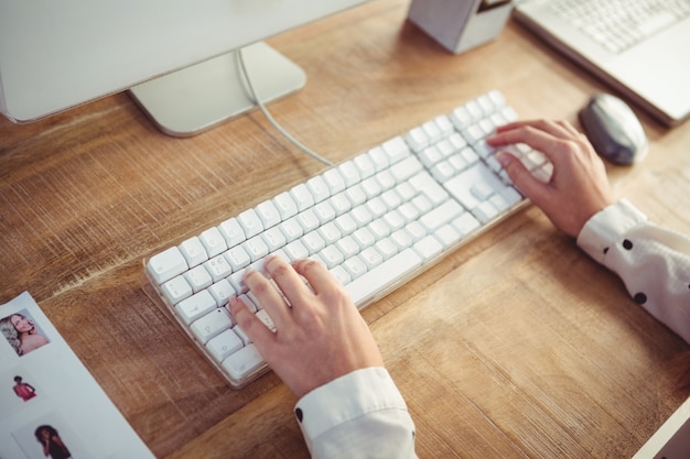 Cropped image of woman typing on keyboard 