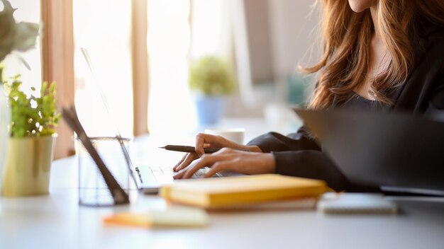 Immagine ritagliata di una donna che utilizza il computer portatile donna d'affari digitando sulla tastiera del computer portatile
