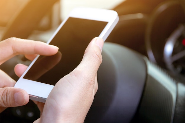 Cropped image of woman using mobile phone in car