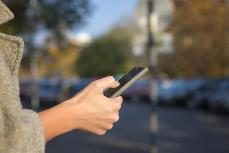 Photo cropped image of woman using mobile phone in city
