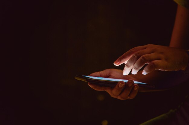 Cropped image of woman using mobile phone