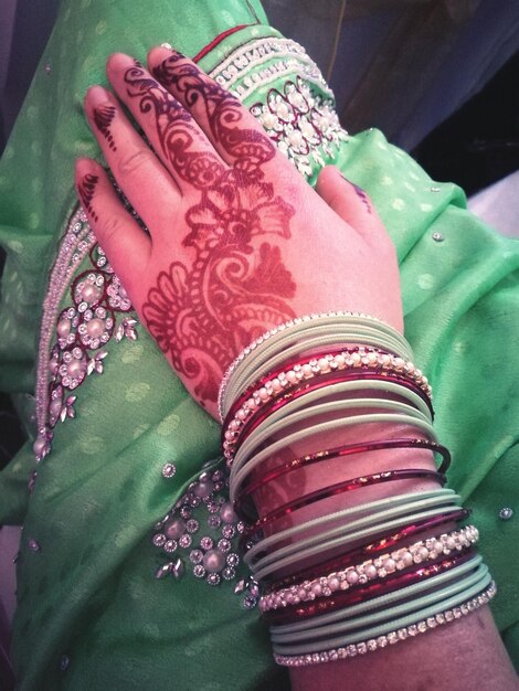 Photo cropped image of woman with bangles and henna tattoo