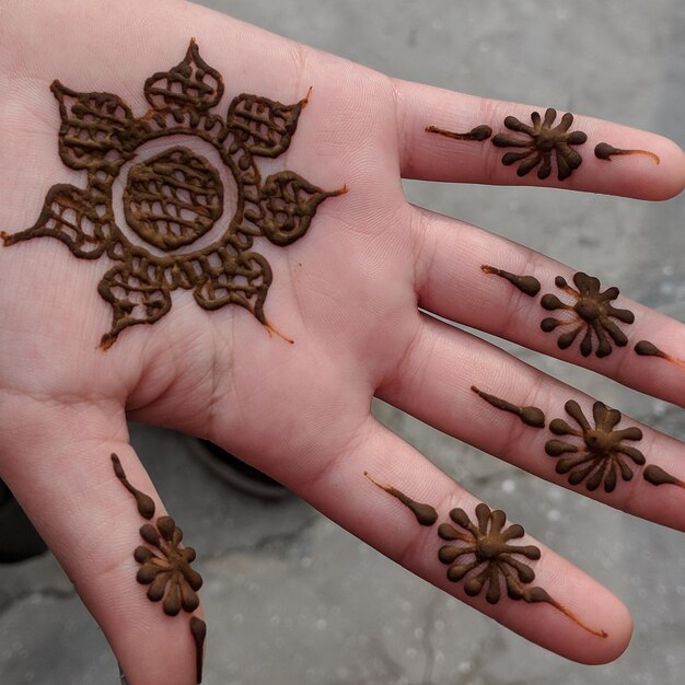 Photo cropped image of woman with henna tattoo on hand