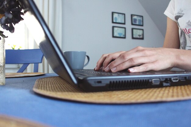 Cropped image of woman working on laptop