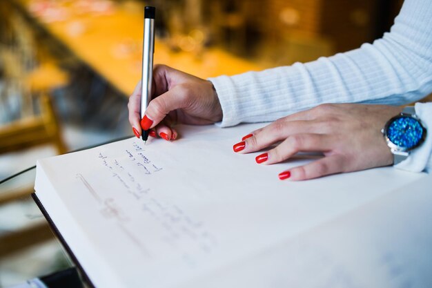 Foto immagine ritagliata di una donna che scrive su un libro