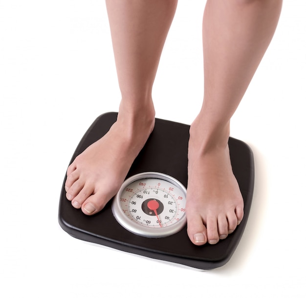 Cropped image of women feet standing on weigh scales. Diet concept