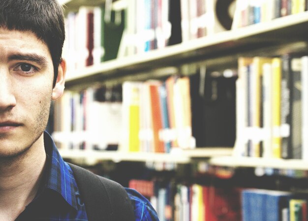 Photo cropped image of young man in library