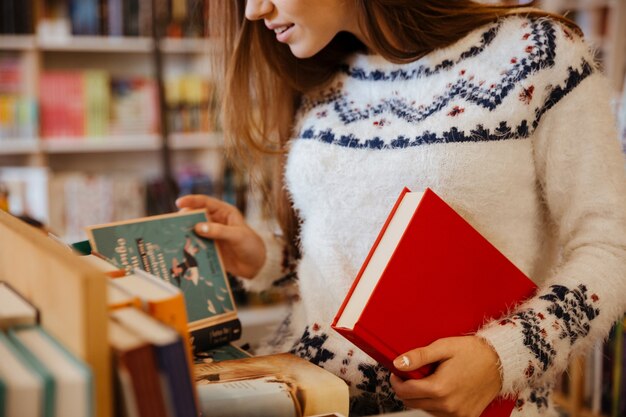 Cropped image of a young woman choosing books in library