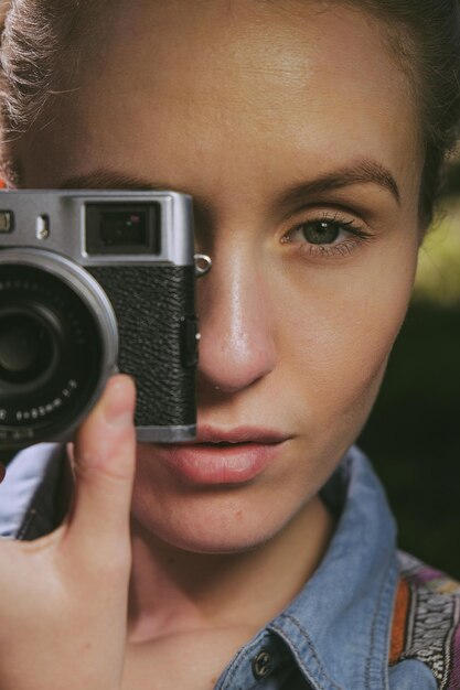 Photo cropped image of young woman photographing with vintage camera