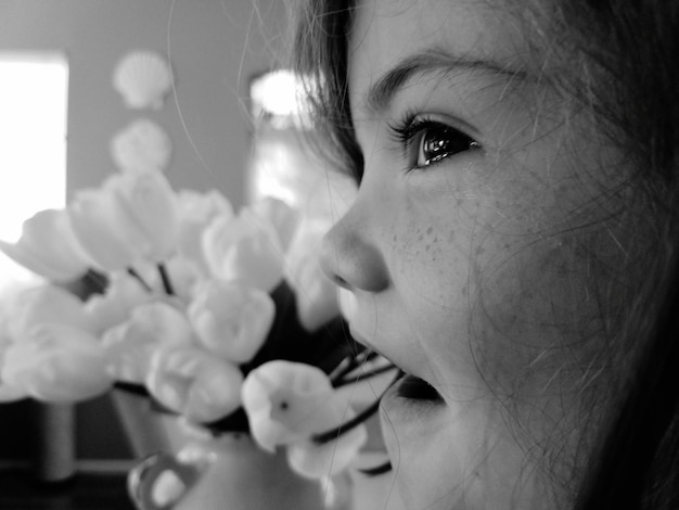 Photo cropped image of young woman with flowers in background