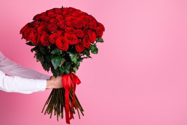Photo cropped man arms hold big one hundred red bright roses