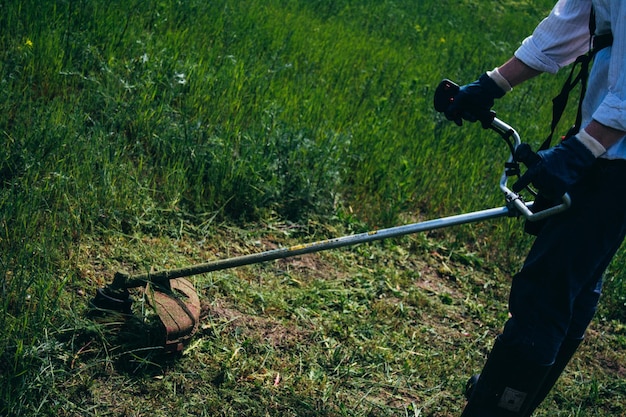 Photo cropped man mowing grassland