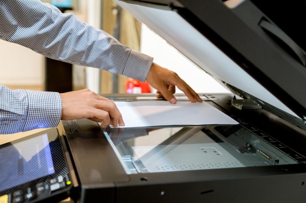 Photo cropped man printing paper photocopier in office