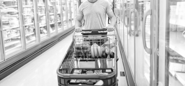 Cropped man with shopping cart buying food at grocery shopping