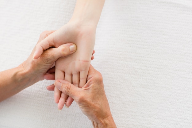 Photo cropped masseur giving hand massage to woman