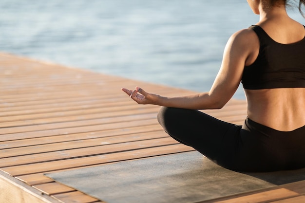 Cropped of meditating african american woman seaside background