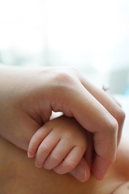 Foto madre ritagliata che tiene la mano del bambino