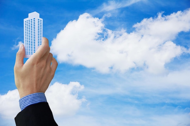 写真 雲の空にモデルビルを掲げているビジネスパーソナルのクロップ
