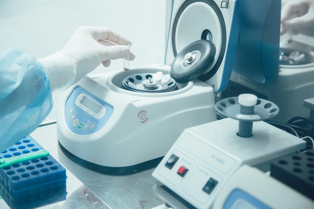 Cropped photo of a lab assistant in rubber gloves taking a micro tube and putting it into a vortexer